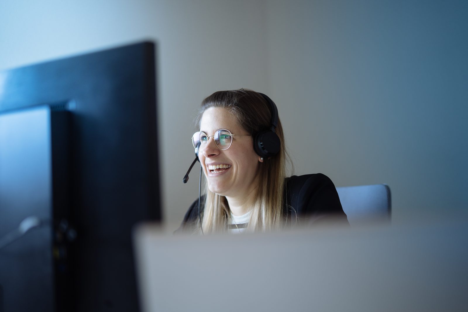 Mitarbeiterin im Kundenservice mit Headset
